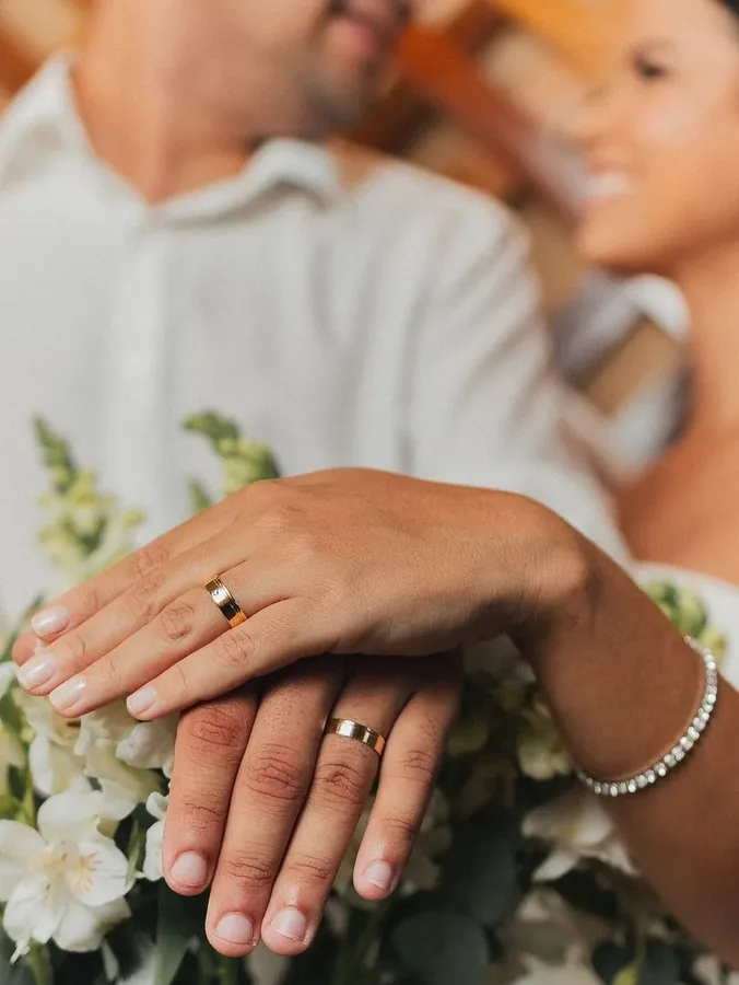 Casal cliente exibindo alianças Ouro Fino